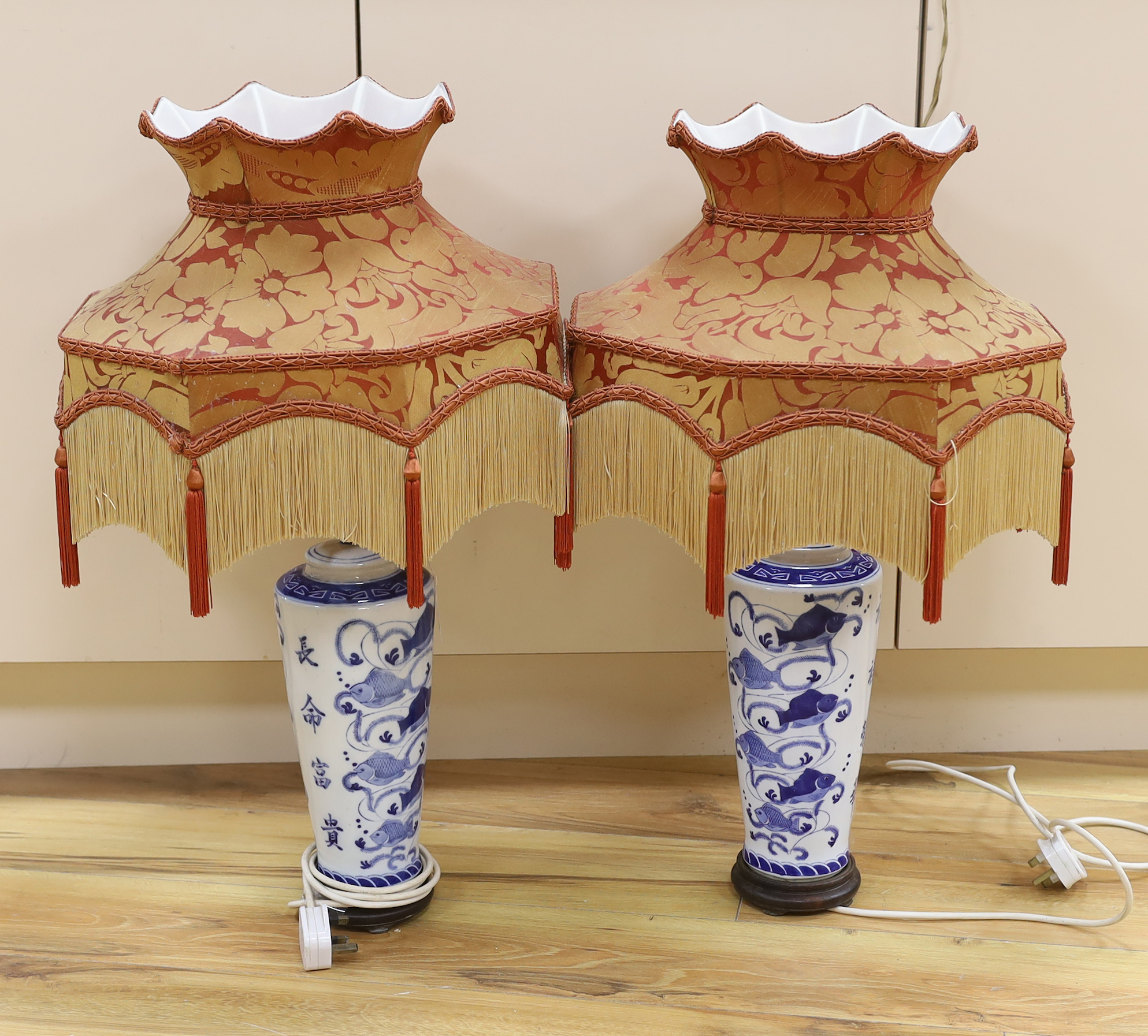 A pair of ‘Chinese’ blue and white table lamps with silk Pagoda shades, 69cm high overall